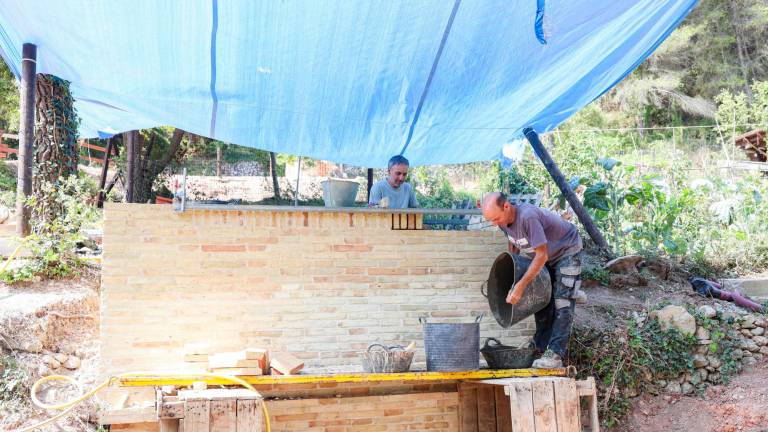 Joan Ferrer y Josep Matés, alfareros, trabajando en la rehabilitación del horno de teja. foto: Àngel Ullate