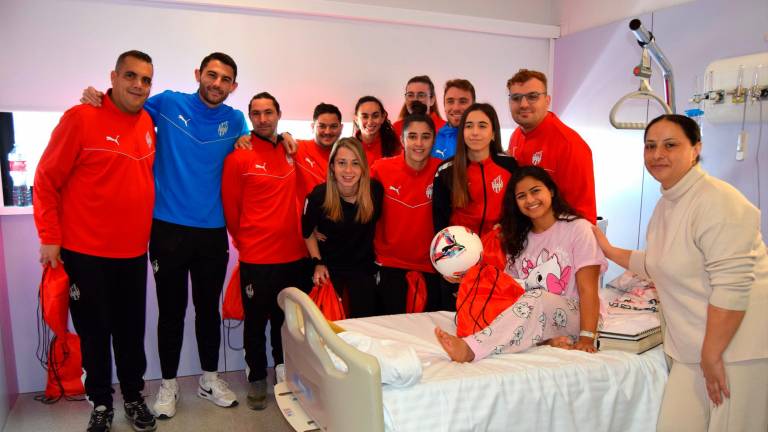 La plantilla del Reus femení i el Genuine amb una pacient de l’hospital. Foto: Cedida