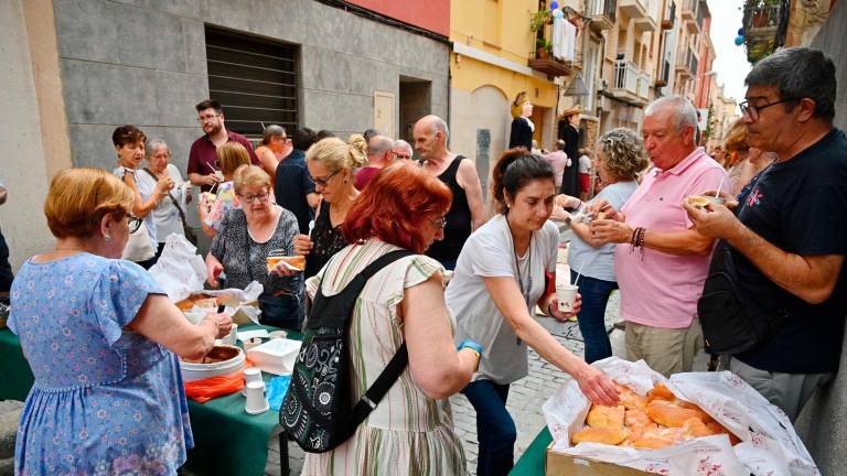Els veïns del Carme de Reus, ahir menjant coca dolça. Foto: A. GONZÁLEZ