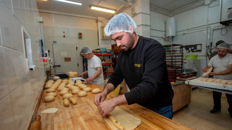 Aleix Solà en el obrador de Calafell elabora el Roscón de Reyes de mazapán. Coloca la figura del rey y el haba en su interior. Foto: Marc Bosch