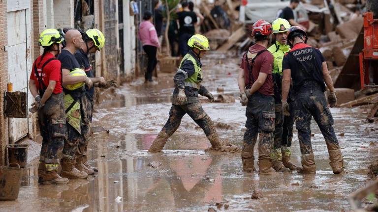 Efectivos del cuerpo de bomberos trabajan en la limpieza y retirada del lodo en Alfafar (Valencia), este viernes. Foto: EFE