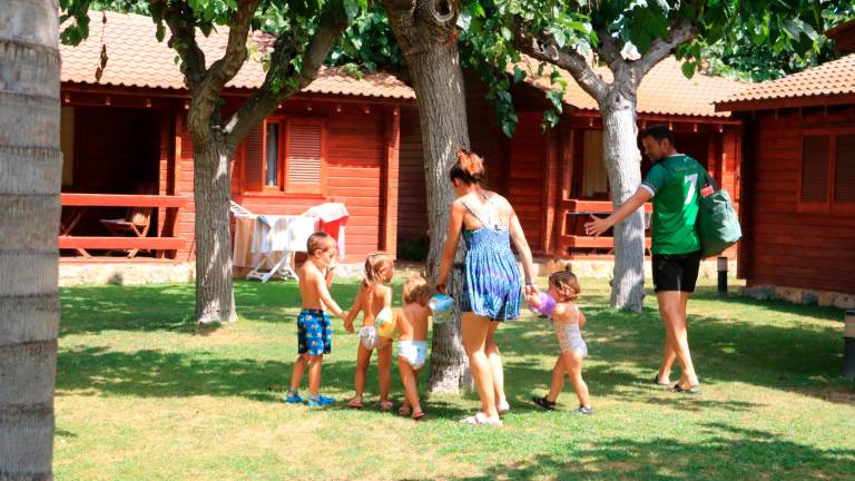 Una familia, frente a un bungalow del camping La Llosa de Cambrils. Foto: ACN