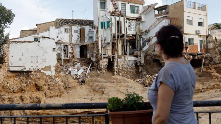 Una mujer observa varias casas dañadas en Chiva, aquejadas con riesgo de derrumbe. FOTO: Kai Försterling / EFE