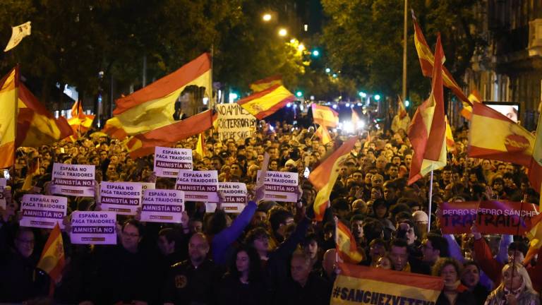 Personas muestran pancartas durante una nueva manifestación convocada contra la amnistía este jueves, en la calle Ferraz, en Madrid, donde se encuentra la sede del PSOE. Foto: EFE/Sergio Pérez