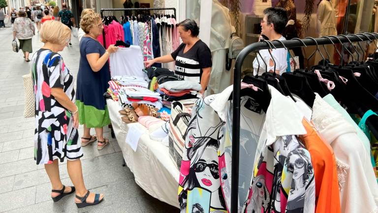 Clientela interesándose por el género de una de las tiendas, en la anterior edición de verano de ‘Les Botigues al Carrer’. Foto: Alfredo González