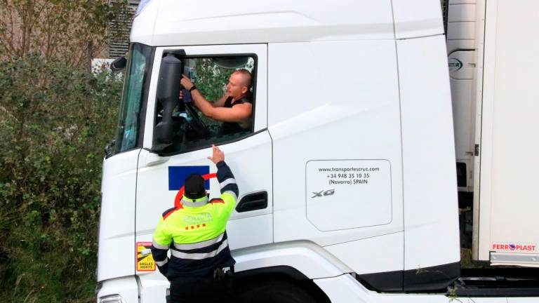 Un mosso ayuda a un camionero que ha quedado atrapado en Llers. Foto: ACN