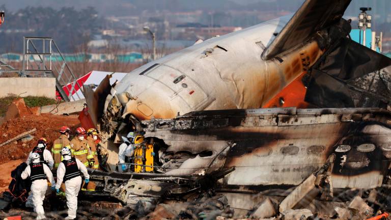 Los bomberos trabajan en los restos del avión Jeju Air en el Aeropuerto Internacional de Muan. FOTO: EFE