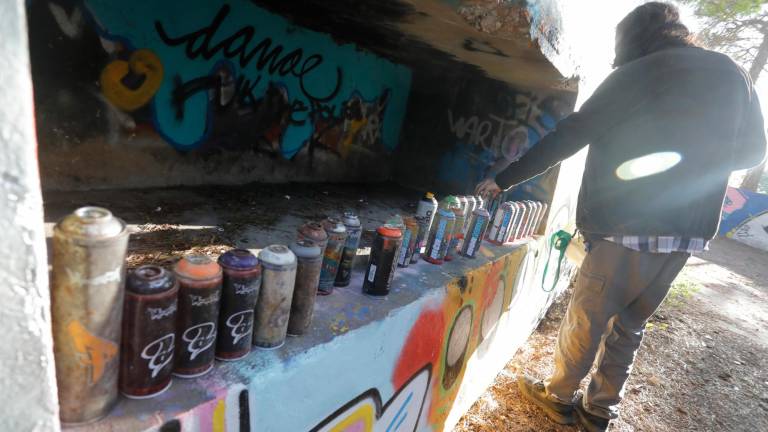 Toda la zona está cubierta al milímetro de grafittis. En la foto, un joven con latas de pintura de distintas épocas. Foto: Pere Ferré