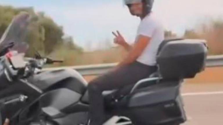 El conductor de la moto, saludando al del coche que lo filmó.