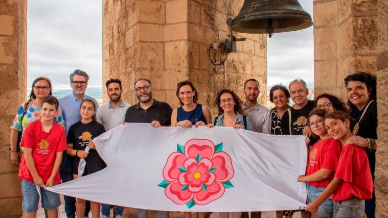 Els quatre portadors i els quatre membres de la comissió de la Cucafera, acompanyats per Sandra Guaita i Daniel Recasens (centre) i altres regidors, amb la bandera de Reus al campanar. FOTO: Ajuntament de Reus