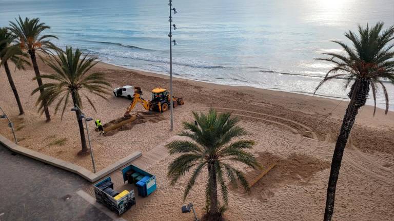 La instalación de barreras de cañas para retener la arena que arrastra el viento en la playa de Calafell. Foto: DT