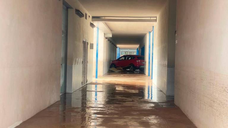 Un edificio con un coche inundado en Catarroja en la mañana del 30 de octubre, con los desastres provocados por la DANA. Foto: Carles Miguel Romeu