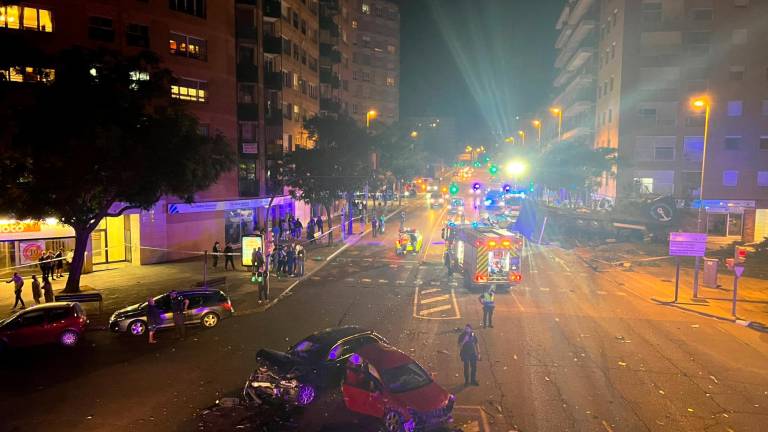 Vista del acceso a Lleida por el Passeig de Ronda en la zona de los Institutos con coches arrastrados por el camión y el tráiler al fondo tras impactar contra un edificio. Foto: ACN