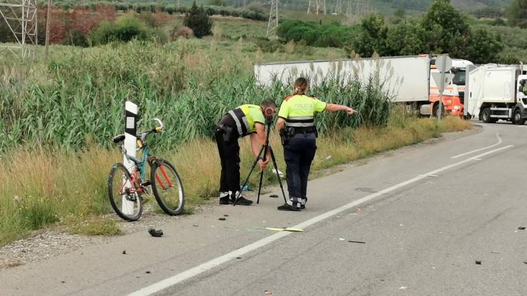 Dos mossos d’esquadra junto a la bicicleta del ciclista fallecido en Botarell. Foto: Àngel Juanpere