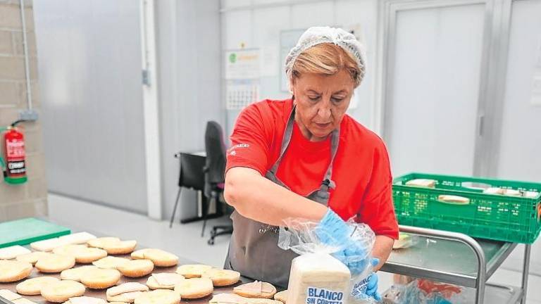 $!Una voluntaria del Centre social El Roser, preparando bocadillos para entregar a los usuarios. FOTO: alba mariné