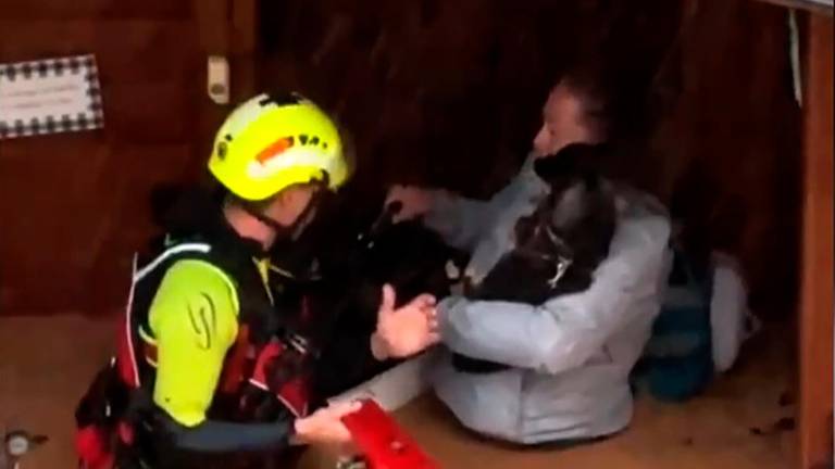 Un integrante de las fuerzas de socorro rescatando a una mujer dentro de una inundación en Valencia. Foto: EFE