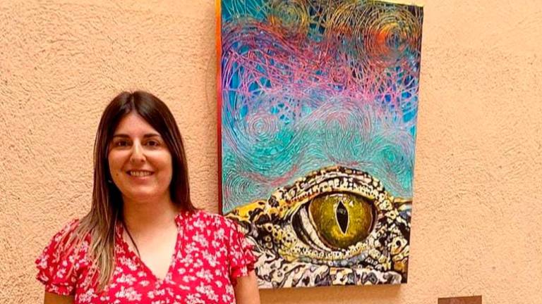 La artista vallense Carina Miras, al lado de la pintura inspirada en la trayectoria de la australiana Val Plumwood. FOTO: CEDIDA