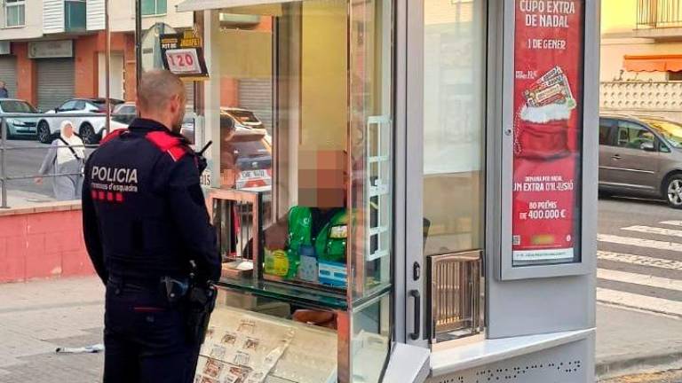 Un agente con la víctima en su quiosco de la calle Riu Fluvià. Foto: CME