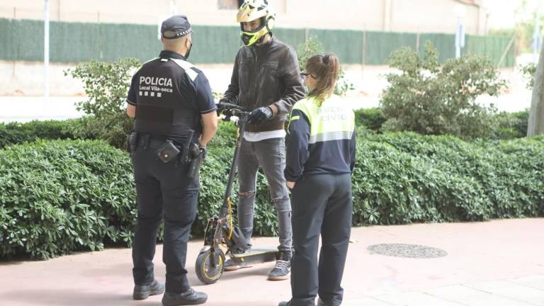 Un policía y una agente informan a un usuario de patinete de que debe ir por la calzada según establece la ordenanza municipal. FOTO: Alba Mariné