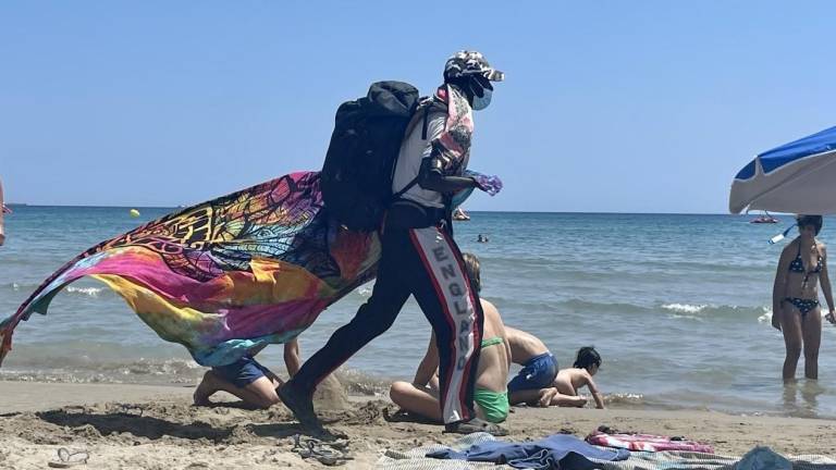 Imagen de archivo de un vendedor del top manta en la arena de la playa de La Pineda este verano. FOTO: Alba Mariné