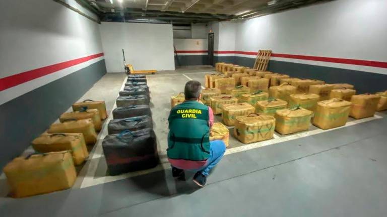 $!Un agente de la Guardia Civil con fardos de droga decomisados. Foto: Guardia Civil