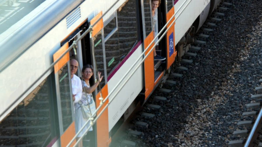 Imatge d'arxiu de passatgers indignats a la porta d'accés del tren de l'R16 aturat a l'Almadrava, al terme municipal de Vandellòs i l'Hospitalet de l'Infant, el 25 de juliol del 2016. ACN.
