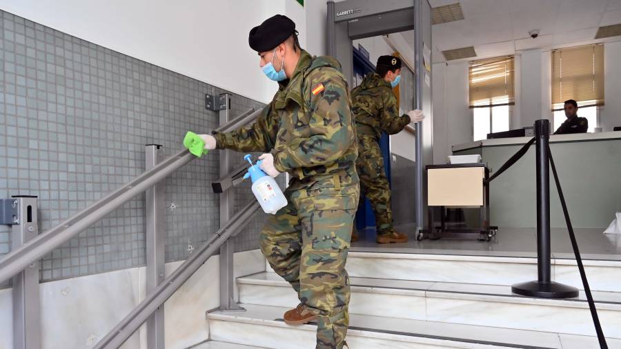 Un soldado limpia la barandilla de las escaleras de acceso de la comisaría de Reus. FOTO: Alfredo González