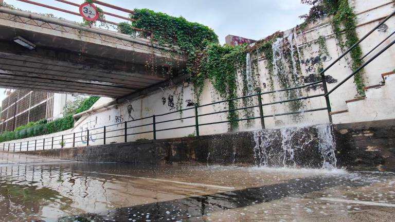 El agua de la antigua vía del tren de Cambrils cayendo a un paso inferior. Foto: David Jiménez